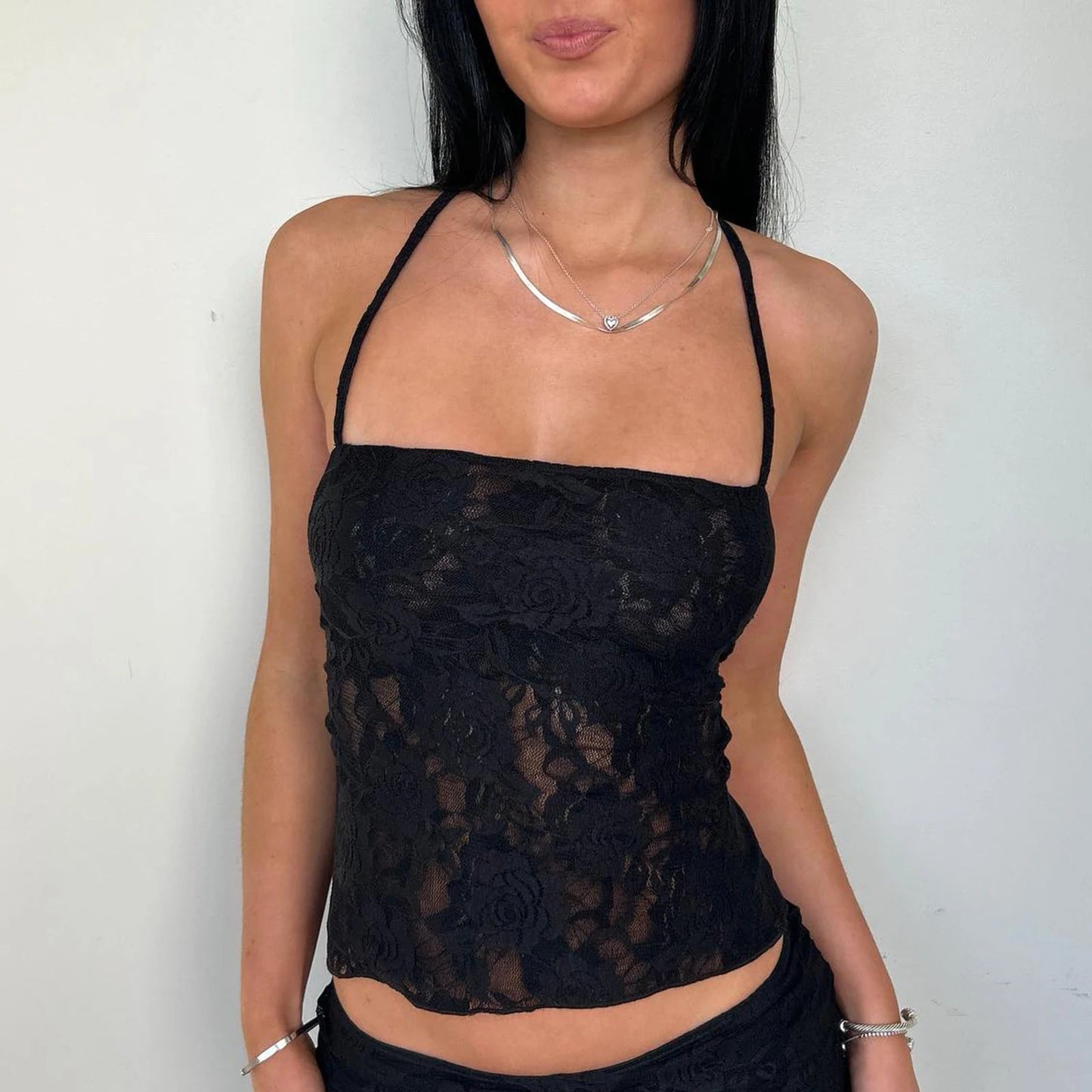 Elevate your summer wardrobe with the Gaono Women Lace Camisole, a perfect blend of elegance and allure. This stunning backless crop top features delicate lace and cross lacing details, making it a must-have for summer outings or evenings out.