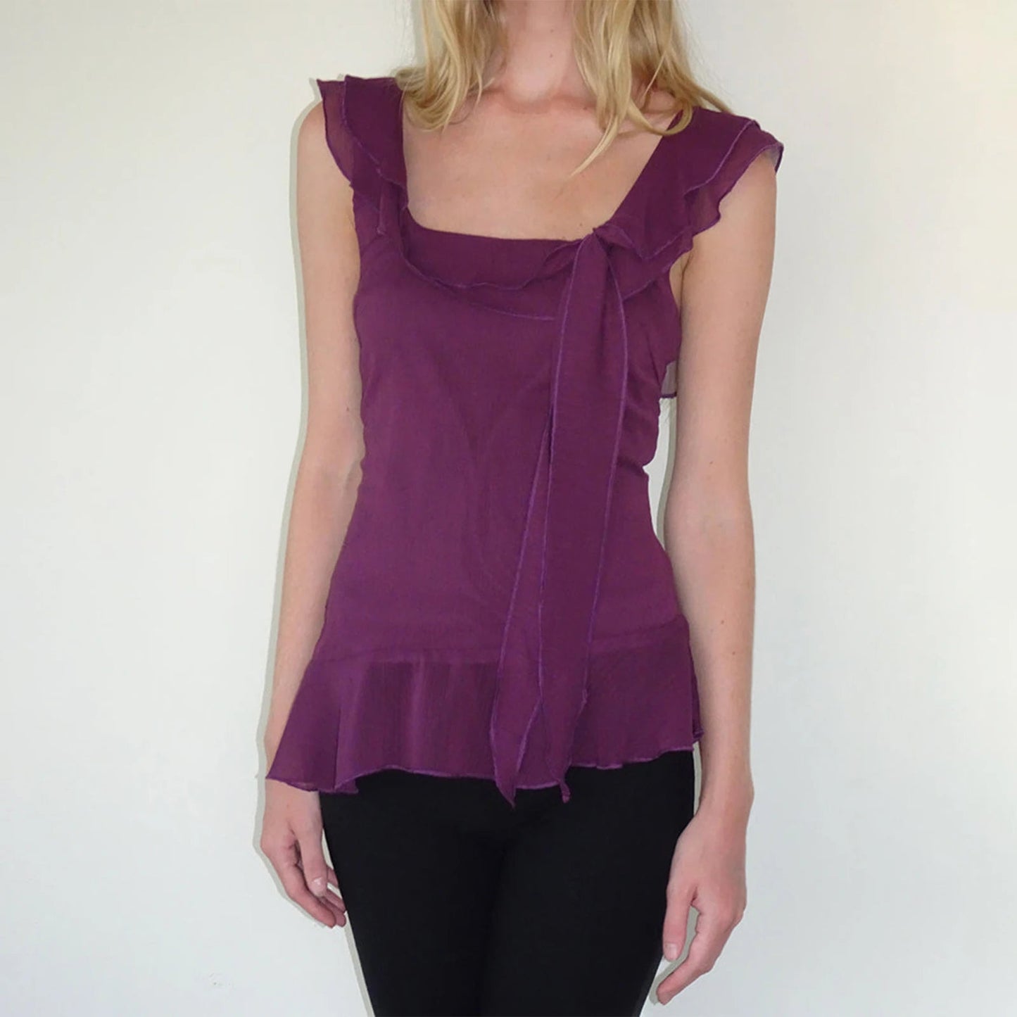 Chic Y2K-inspired crop top in a stunning purple hue, designed with charming ruffle trims and a square neck for a feminine flair. Crafted from a soft cotton-polyester blend, this lightweight tank offers a flattering fit with slight stretch, making