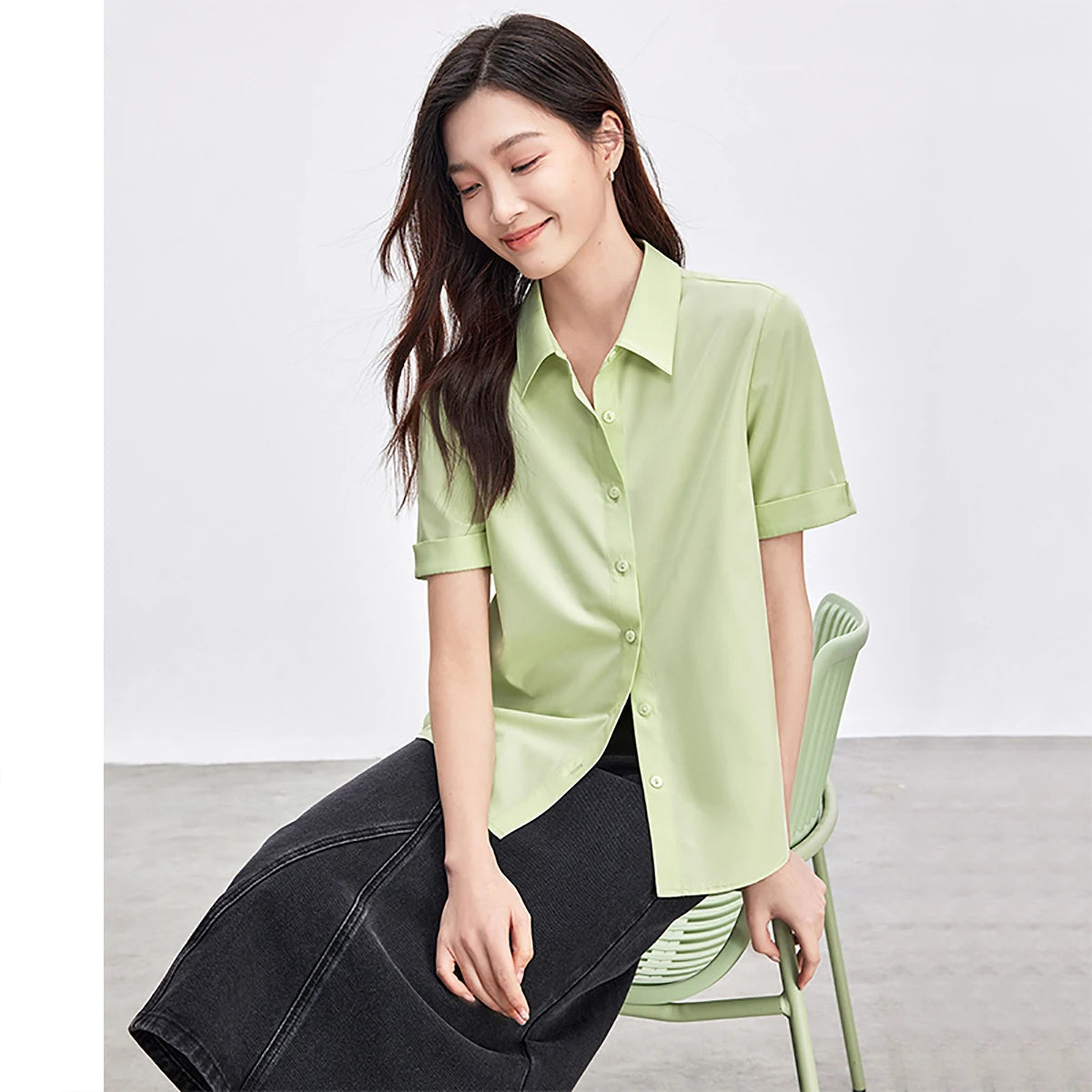 Woman wearing a light green shirt sitting on a chair
