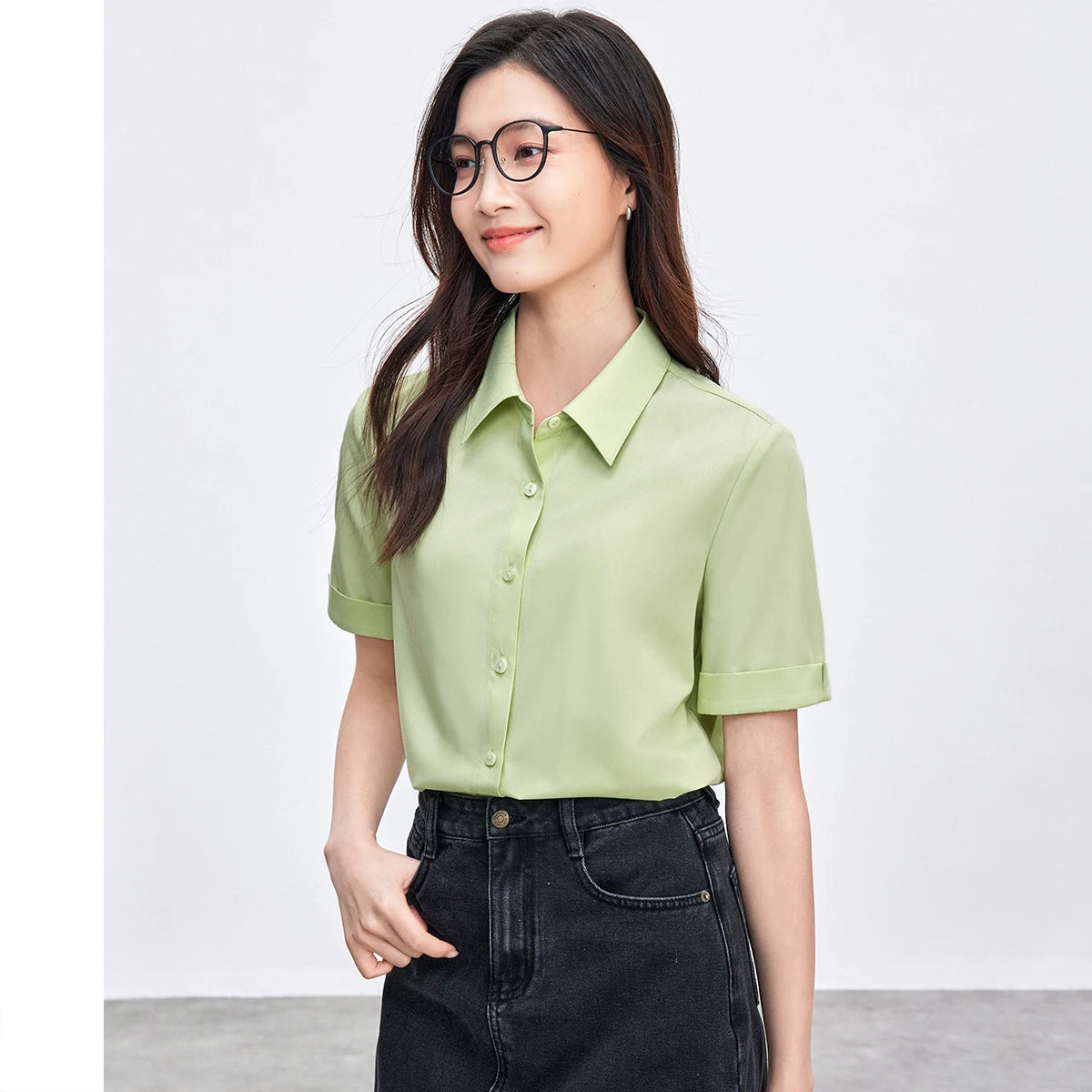 Woman wearing a light green shirt and black pants